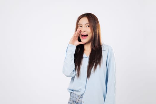 Shouting woman places hands on mouth while another woman makes a loud announcement, eyes wide with joy, expressing surprise and excitement isolated on a clean white background.