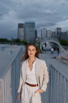 A stylish woman in a tailored business suit poses confidently in an urban setting, exuding professionalism and sophistication with a contemporary city skyline.