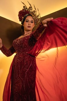 Princess wearing a red dress with the gold crown on her head in front of the lighting in the background