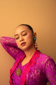 Asian woman touches her head while posing with makeup inside the studio