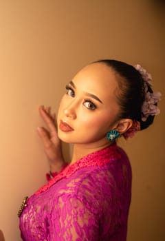 Balinese bride wearing the pink wedding dress before the ceremony has started inside the temple