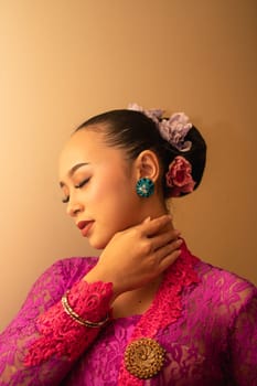 Asian woman touching her neck and feeling sexy with herself while posing inside the cream room