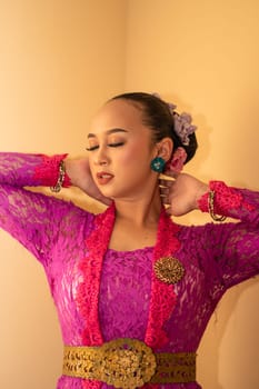 Balinese bride wearing the pink wedding dress before the ceremony has started inside the temple