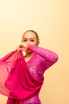 Javanese woman wearing traditional pink dress called kebaya on the Indonesian independence day