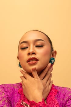 Sexy Asian woman wearing a pink dress called kebaya with a hot pose inside the studio