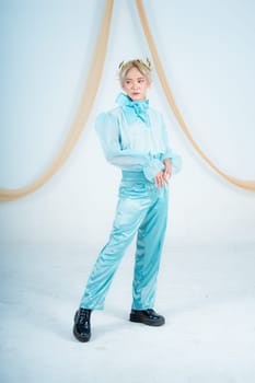 an Asian woman with blonde hair posing with her hands in a white studio