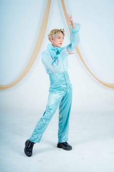 an Asian woman with blonde hair posing with her hands in a white studio
