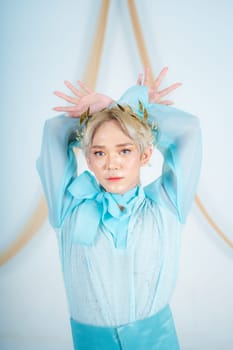 an Asian woman with glowing makeup posing very elegantly in a white room