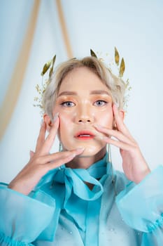 beautiful face of an asian woman with red lipstick and blue eyes in a white studio