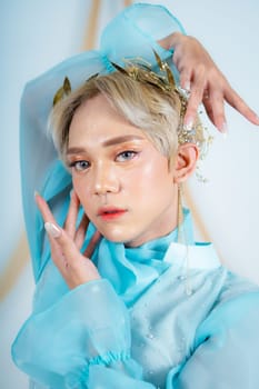 a princess with a blue dress and blonde hair posing very beautifully in front of a white background