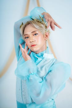 a princess with a blue dress and blonde hair posing very beautifully in front of a white background