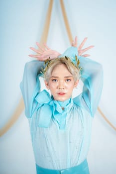an Asian woman with glowing makeup posing very elegantly in a white room
