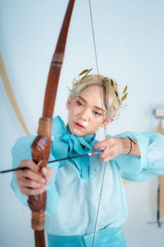 a princess in a blue dress pulling a bow with her hand in a white room