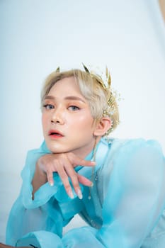 a woman with flawless makeup wearing a golden crown on her blonde hair in a white room