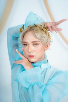 a royal princess in a blue dress posing with her hands very elegantly in a white palace