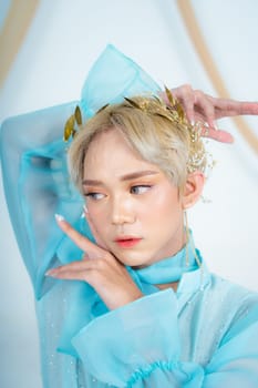a royal princess in a blue dress posing with her hands very elegantly in a white palace