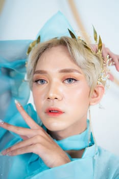 a royal princess in a blue dress posing with her hands very elegantly in a white palace