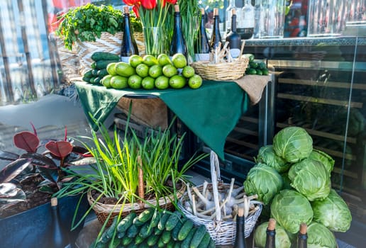 Street market stall with fresh vegetables. Cucumbers, cabbage, garlic, parsley, wine, tulips, zucchini. The first harvest from the greenhouse is on sale.