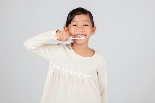 Smiling child with a toothbrush and a tooth gap. The dentist educates on tooth loss and oral care, making daily hygiene an important part of a kid's routine. isolated white background