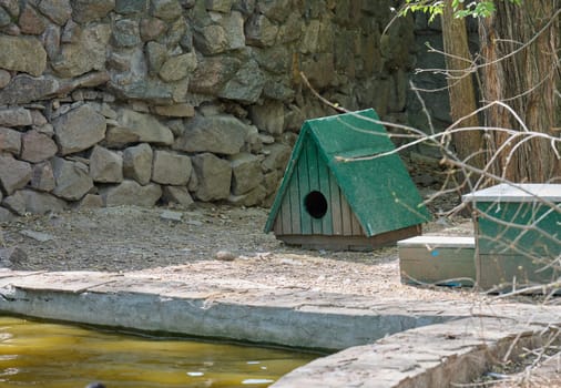 Small green wooden birdhouses with triangular roofs