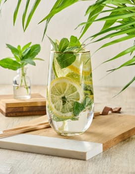 Refreshing citrus and mint drink in glasses with ice, lemon, lime, and mint leaves. Healthy summer beverage