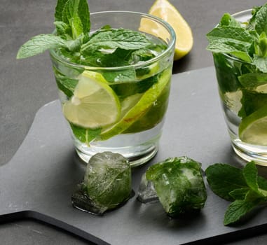 Refreshing mojito cocktail with lime, mint, and ice on dark background
