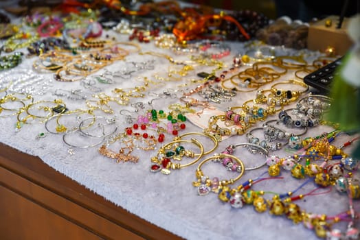 Colorful beaded bracelets with stones and charms for sale at a market in Shanghai, China. Handmade jewelry for small business and retail.