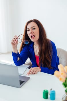 Women brunette woman in business suit with glasses at desk with laptop online