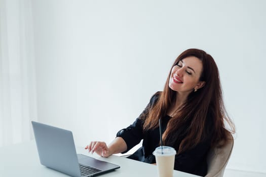 Brunette woman working with desk with laptop in white office online