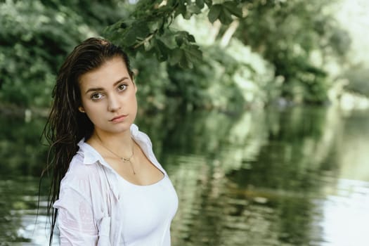 Cool brunette long wet hair girl is posing on camera outdoors. Edited as a old  photo.. Horizontally. 