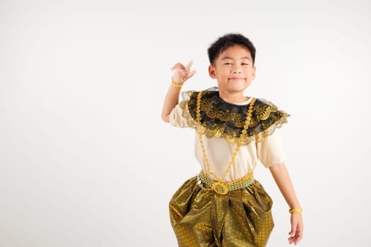 Portrait Thailand kid boy smiling traditional Thai dress costume radiates positivity by forming victory and peace signs, studio shot isolated white background, primary child V sign finger