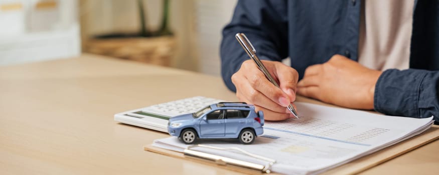 Signing a car lease paper or agreement, ensuring finance, loan, or rent terms. Perfect for vehicle purchases or dealership transactions in auto sales and insurance contracts.