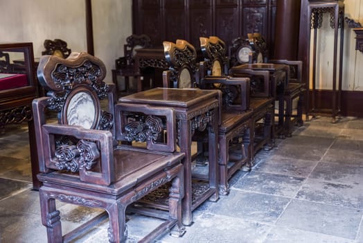 Shanghai, China - 1 April 2025: Artistic banyan root chairs inside He Xu Hall, part of the historic Dianchun Hall in Yuyuan Garden, famous for unique woodwork