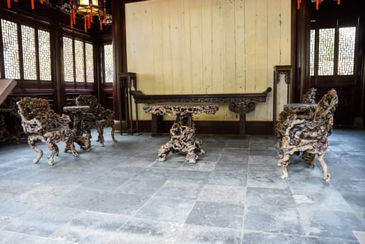 Shanghai, China - 1 April 2025: Banyan root chairs and furniture in He Xu Hall, located within the historic Dianchun Hall of Yuyuan Garden