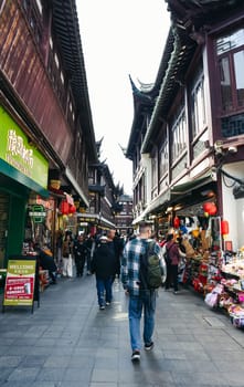 Shanghai, China - 1 April 2025: Tourists explore Yuyuan Old Street, a bustling traditional market with souvenir shops and local vendors in historical Chinese buildings