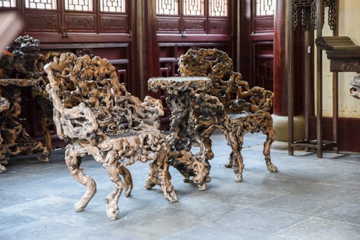 Shanghai, China - 1 April 2025: Interior view of He Xu Hall featuring sculptural chairs made from banyan roots in Dianchun Hall, Yuyuan Garden