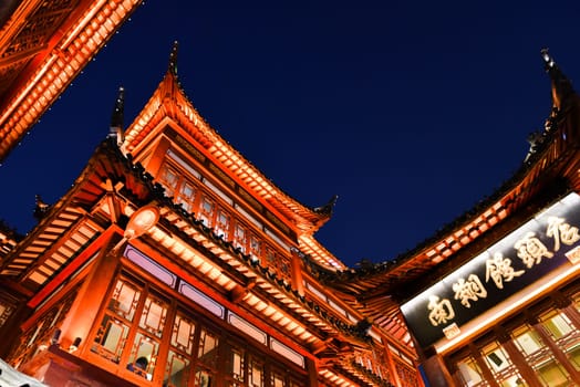 Shanghai, China - 1 April 2025: Illuminated rooftops of Yuyuan Old Street against the night sky, highlighting traditional Chinese design