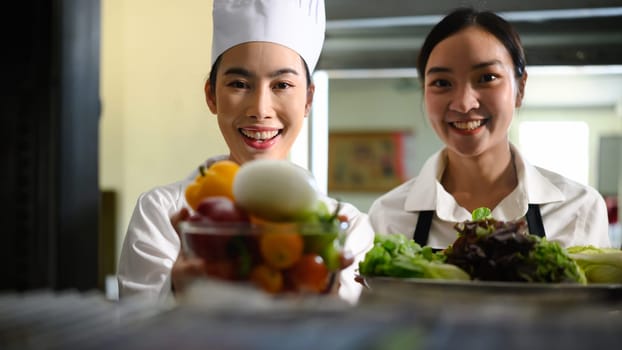 Young chefs preparing ingredients for a cooking class in a professional kitchen.