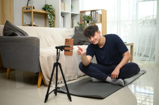 Content creator recording workout session on smartphone at home. in living room.