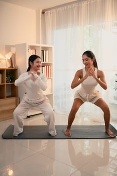 Mother and daughter enjoying a workout session together in a bright, cozy home.