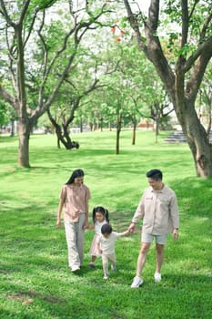 Parents enjoying a peaceful stroll with their children surrounded by vibrant nature.