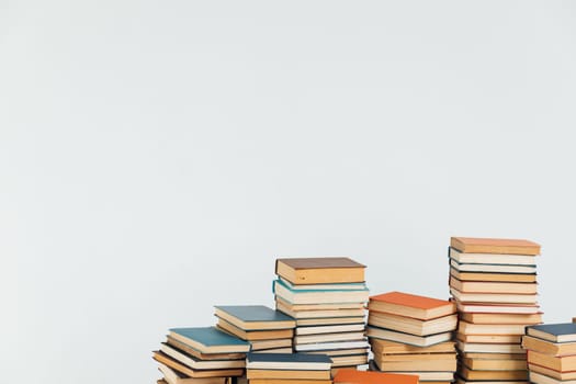 Stacks of old educational books for learning on a white background