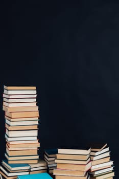 Stacks of old educational books for learning on a black background