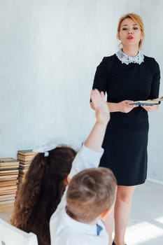 Teacher Conducting Lesson with Book for Children in School Classroom