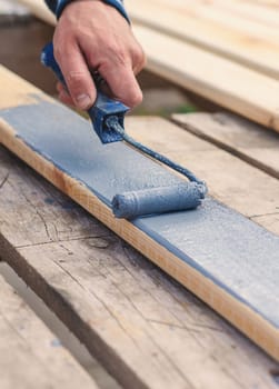 A man paints a board with paint. Selective focus. People.
