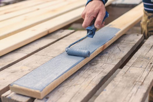 A man paints a board with paint. Selective focus. People.