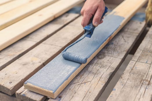 A man paints a board with paint. Selective focus. People.