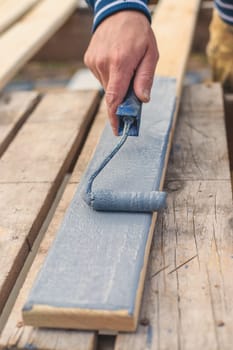 A man paints a board with paint. Selective focus. People.