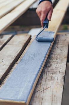A man paints a board with paint. Selective focus. People.