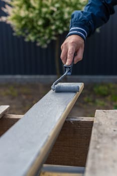 A man paints a board with paint. Selective focus. People.